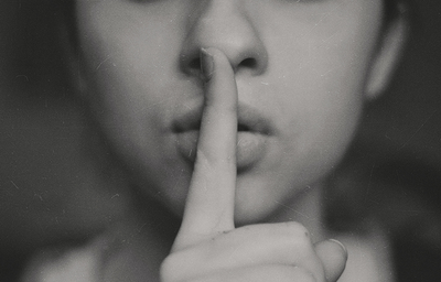 grayscale photo of a person with their finger to their mouth