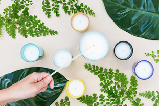 lighting candles surrounded by greenery by Noelle Australia on Unsplash
