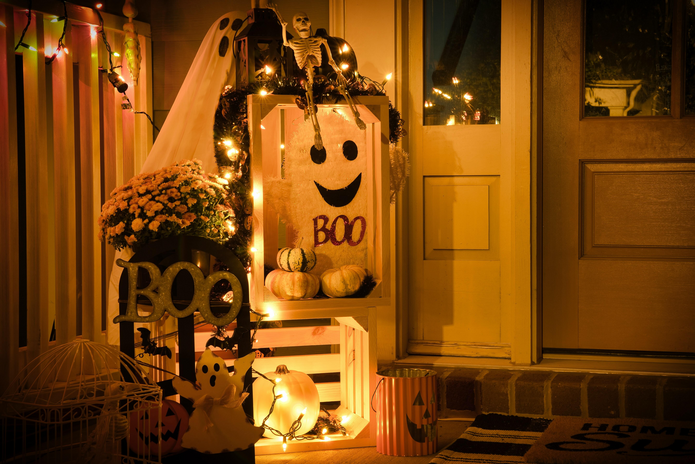front porch decorated for Halloween lit up at night