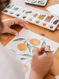 person painting oranges using watercolor