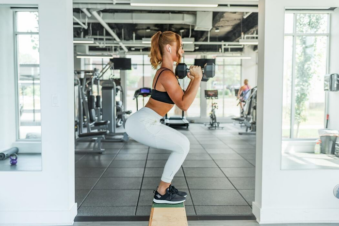 woman doing squats with dumbbells by Benjamin Klaver