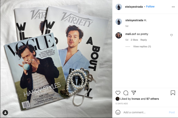 Image of magazines with Harry Styles on the cover laid out on a bed with accessories