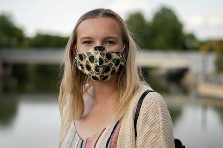 woman wearing sunflower dress and face mask