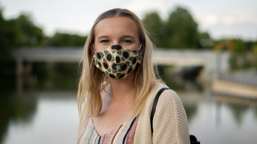 woman wearing sunflower dress and face mask by Unsplash
