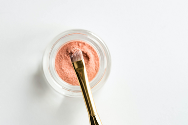 brown makeup brush in pink powder