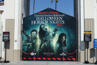 In the image you can see Universal Studios Hollywood\'s top mazes of the year. The haunting of the hill house, the exorcist, and Texas chainsaw. This is the banner outside of their gates in the front of the park.