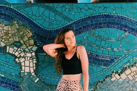 Becca McCandless in front of blue mosaic mural