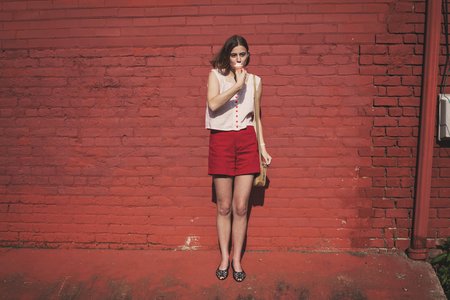girl in front of red brick wall eating ice cream 1