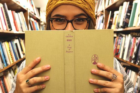 The Lalagirl With Beanie Holding Book Up