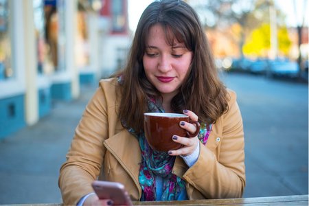 Cara Difabio-Girl Looking At Phone With Coffee