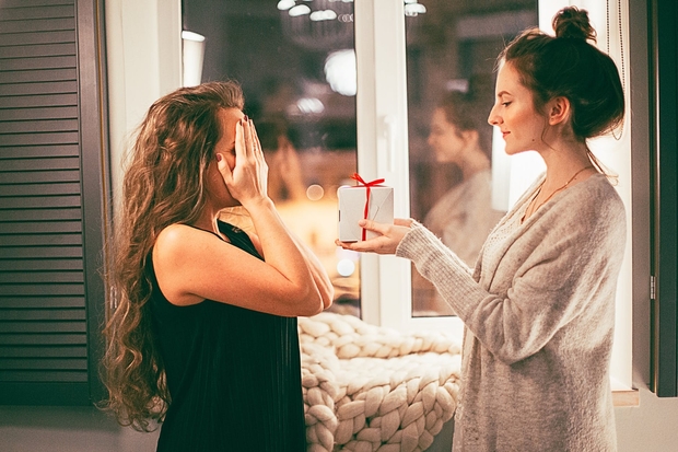 woman giving a gift to another woman
