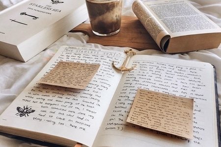 Cath’s photo of coffee, journal and novel on white bed