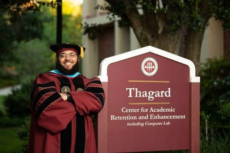 Dr. Starke leaning on "Thagard" sign