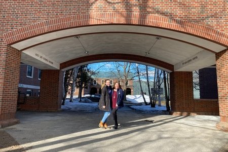 mom and daughter standing under building