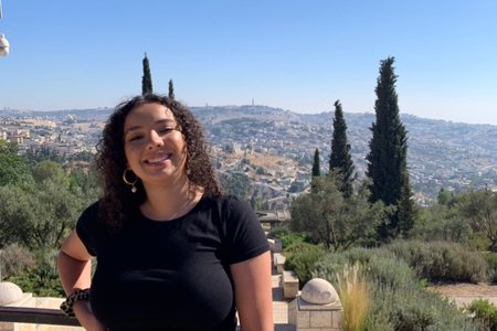 a picture of Kayla Francis in front of greenery in a black shirt