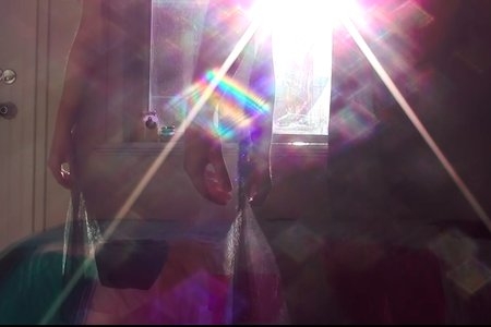 Screenshot from my own film, silhouettes of woman in the light with rainbow image.