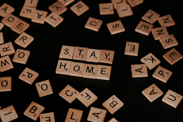 scrabble pieces spelling out \"stay home\"