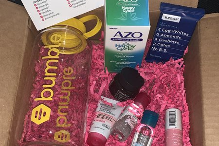 box with pink confetti and products from Garnier, Bumble, Innisfree, Azo, RXBar, and CoverGirl