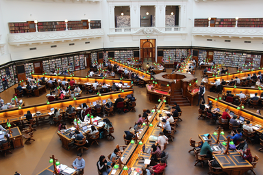 people studying and working side by side in large library