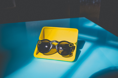 black sunglasses in yellow case on table