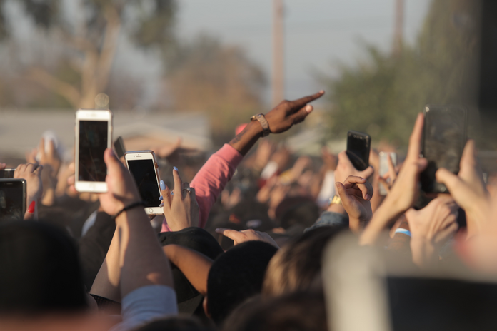 people holding smartphones in a crowd