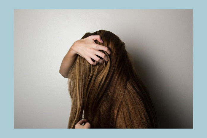 4 Reasons Your Hair Isn’t Growing, According to an Expert 6 woman covering face with her hair