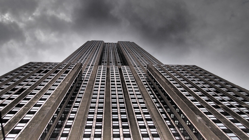 low angle photo of tall building against stormy sky
