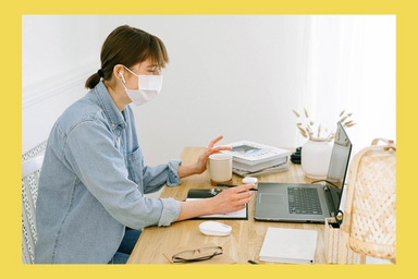 woman wearing face mask doing homework