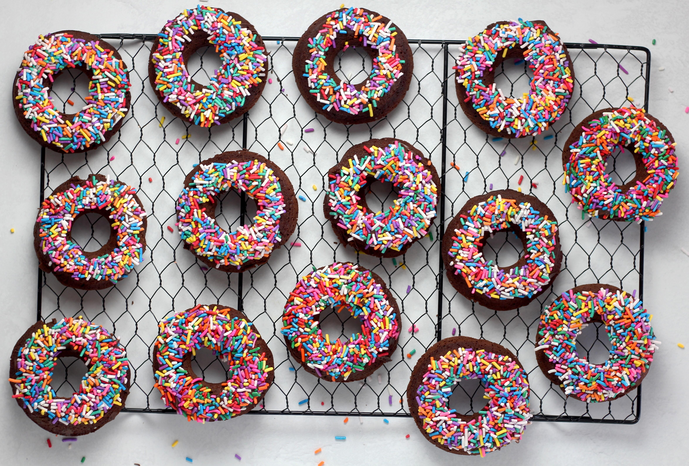 Baked chocolate donuts with sprinkles by sheri silver on Unsplash