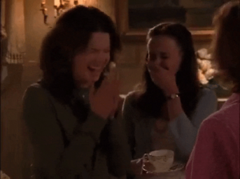 two girls laughing next to each other and one is clapping