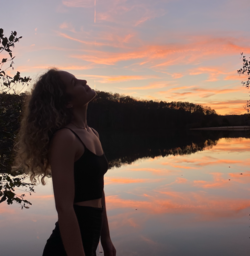 girl in front of lake and sunset