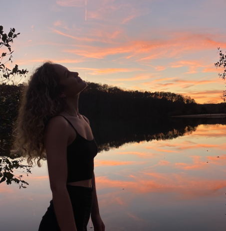 girl in front of lake and sunset