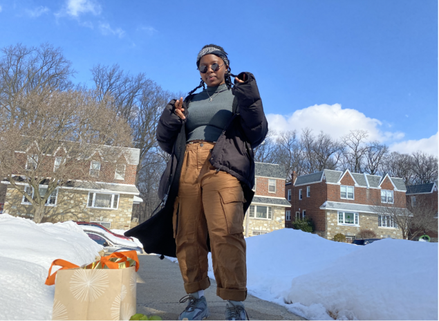 woman standing in front of houses with snow on the ground
