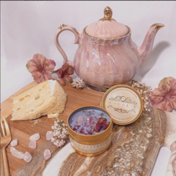 A pink tea pot, crystals and cake on a table