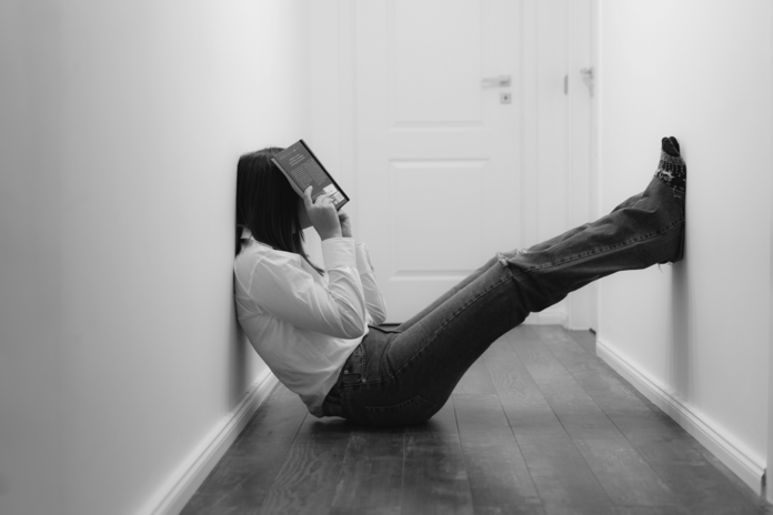 frustrated woman sitting on floor with book