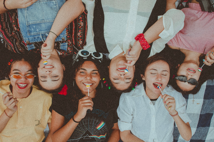 Group of friends side by side with lollipops by Aline Viana Prado
