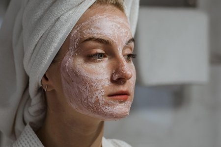 woman with white towel on head and face mask