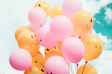 Low angle photo of pink & orange balloons