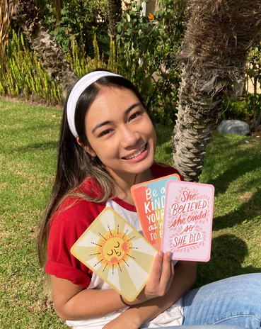 Girl holding Hallmark cards and smiling.