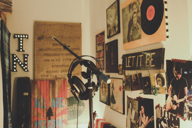 black microphone and headphones in front of poster decorated walls