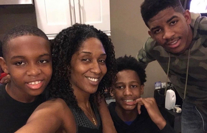 a black woman and three boys smiling