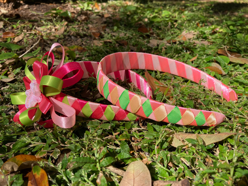 A picture of two green and pink headbands on grass