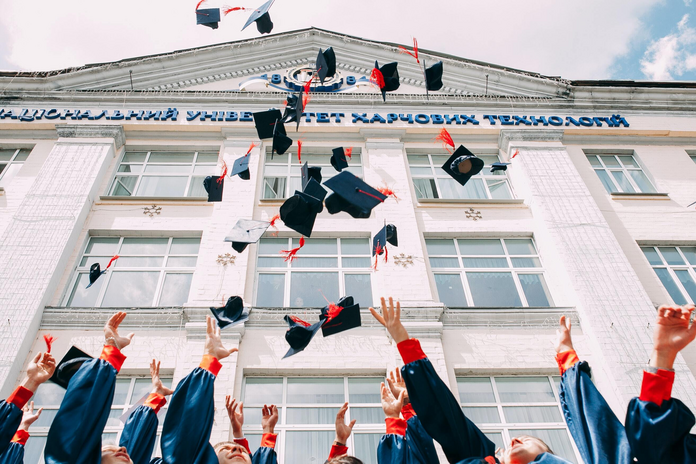graduates throwing caps in air