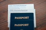 2 passport and vaccine record cards stacked on a table