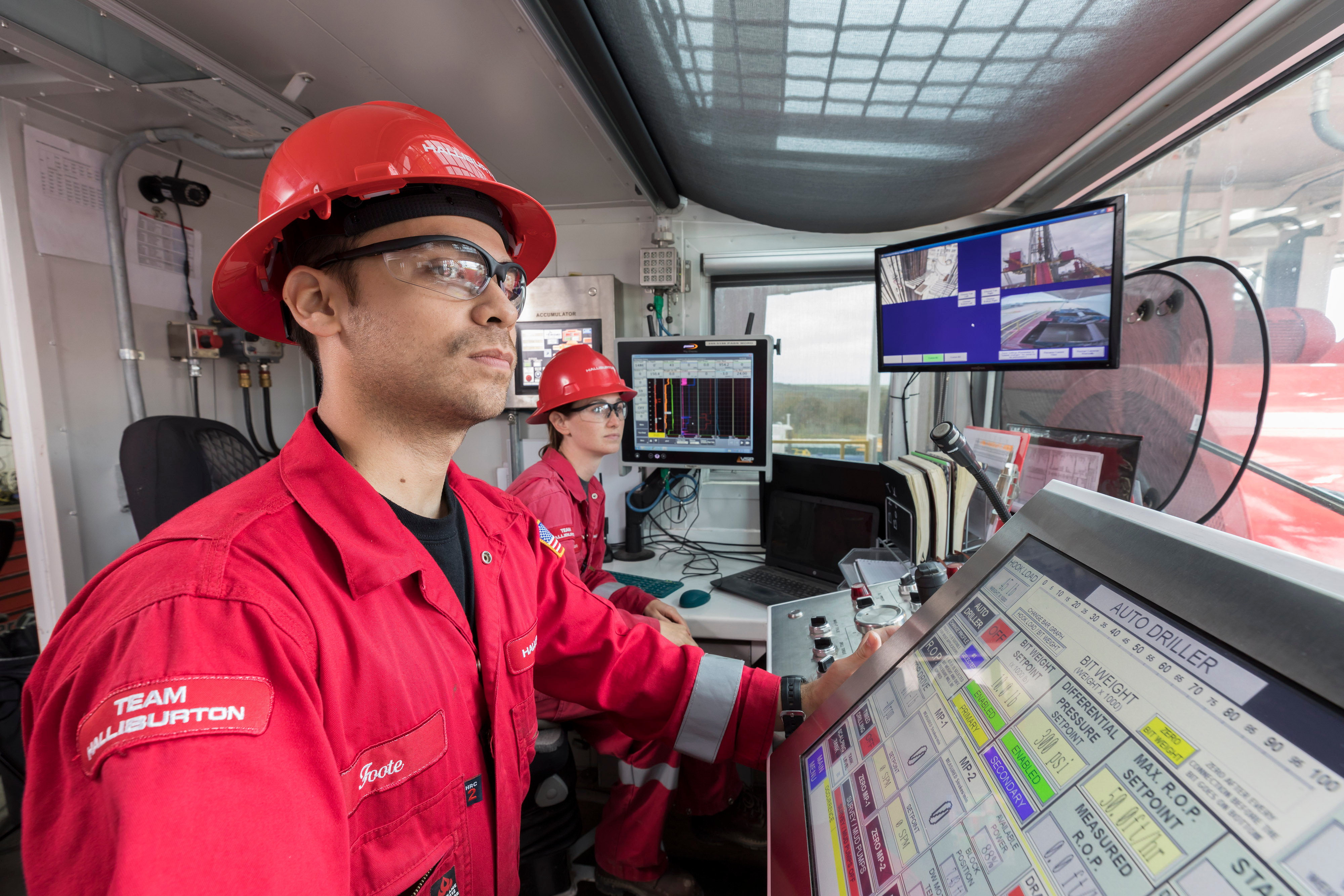 Halliburton employees monitoring rig site operations digitally