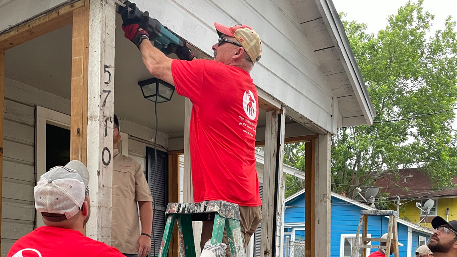 Volunteers install trim around the new porch